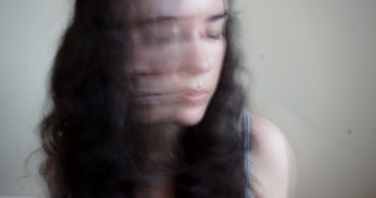 An image of an overexposed woman whose face has blurred but we see her profile