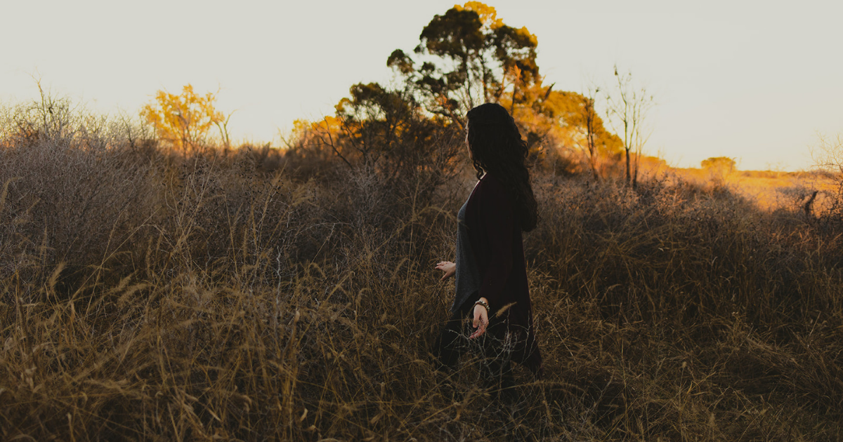 A woman walking through dried brush